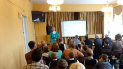 Преподаватель стоит рядом с экраном проектора и читает лекцию